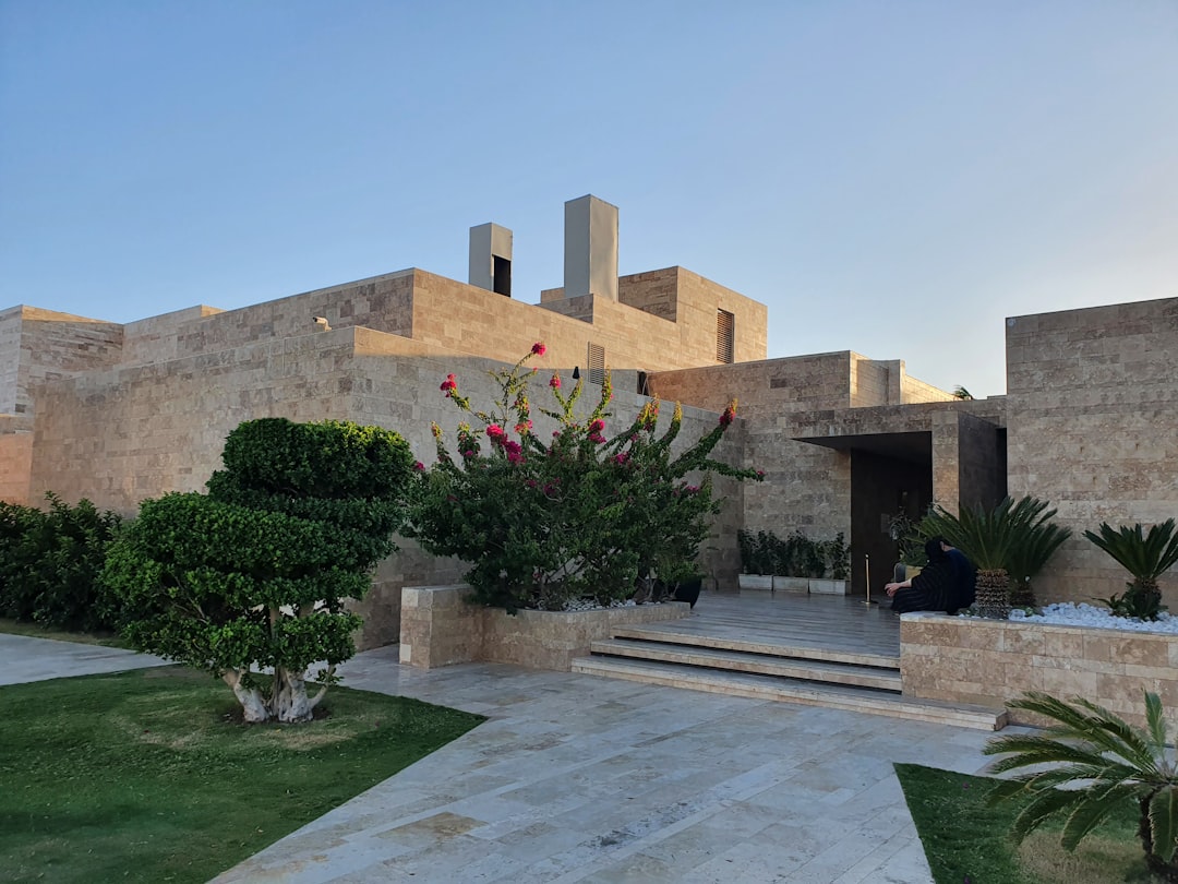 green-grass-field-near-brown-concrete-building-during-daytime-tpd5guu-nuw